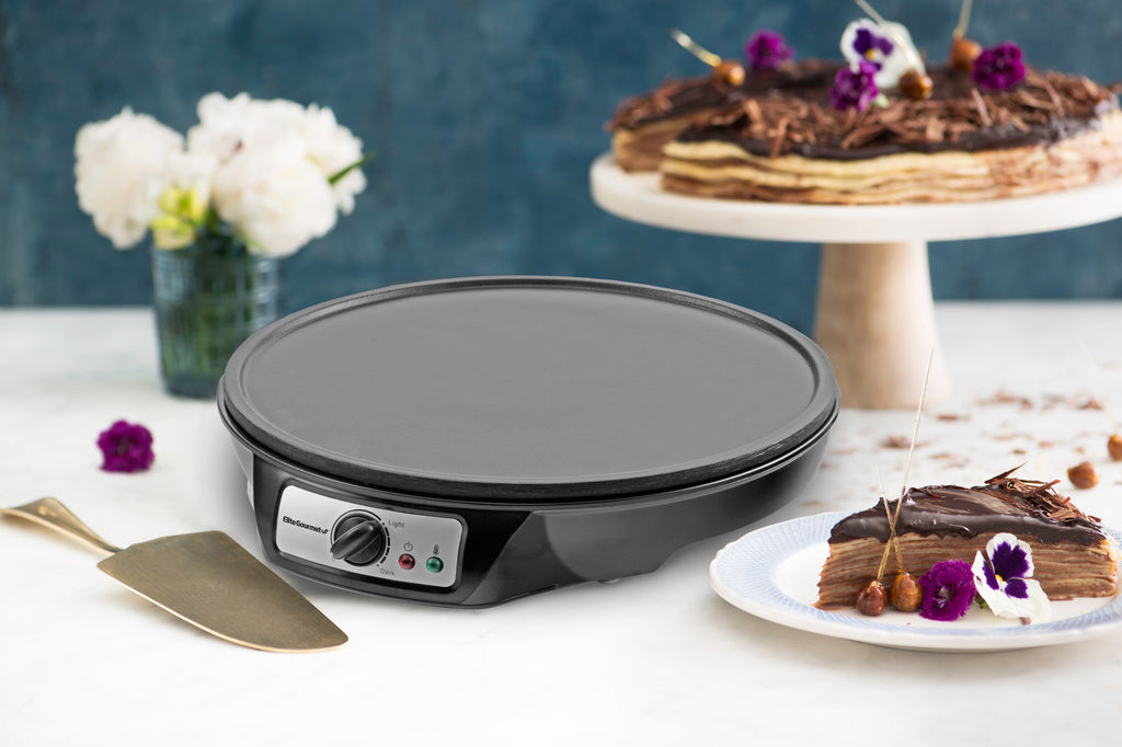 Elite Gourmet Nonstick Electric Crepe Maker & Griddle on the table with cakes.