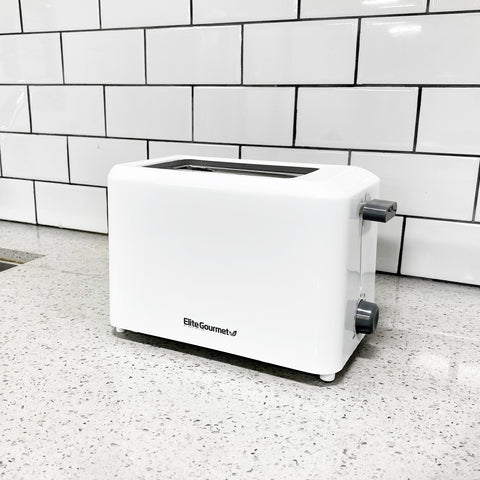 The 2 slice white toaster placing on a marble countertop. 