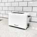The 2 slice white toaster placing on a marble countertop. 