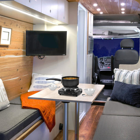 Burner being used inside a camper RV with soup in saucepan.