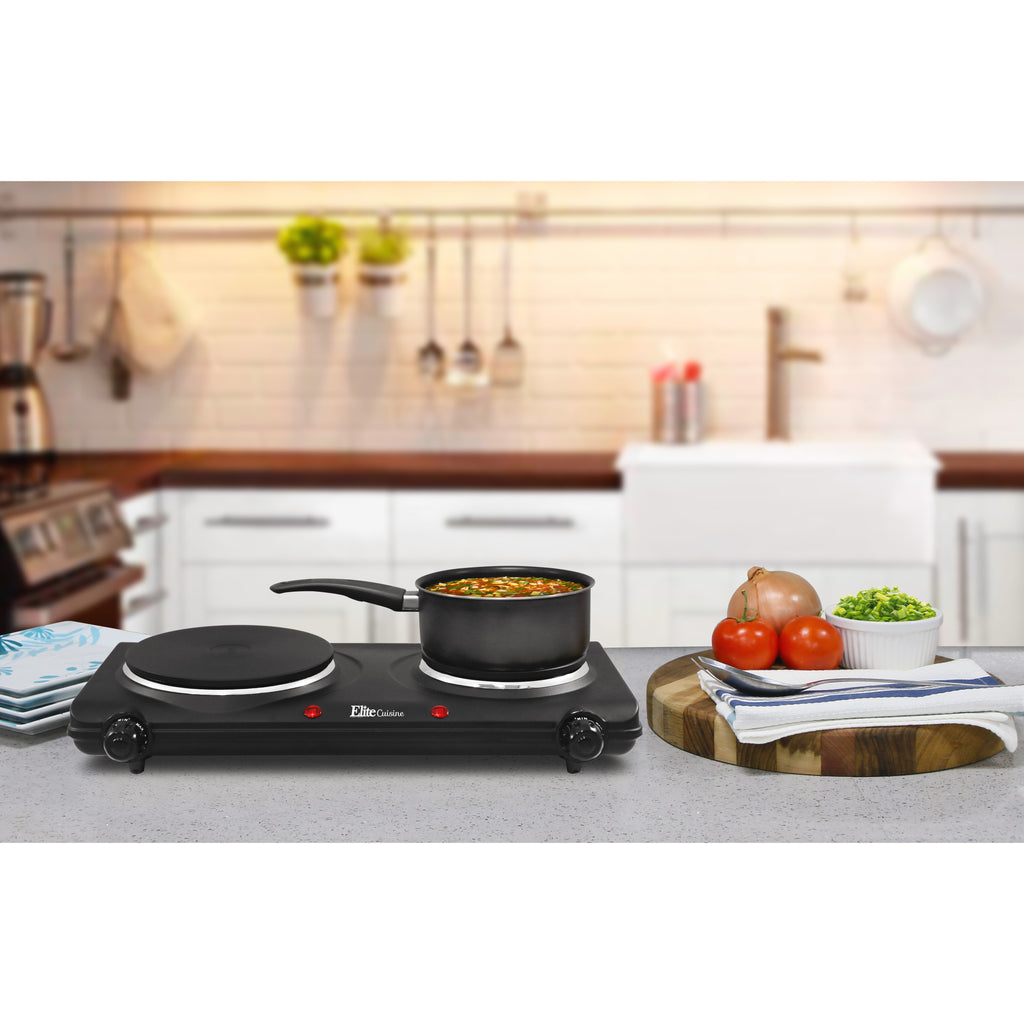 Countertop Electric Dual Flat Burner on kitchen counter with saucepan cooking soup.  Cutting board, vegetables and serving plates next to it.